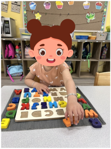 Childcare student in North Delta learning letters with a wooden alphabet puzzle.