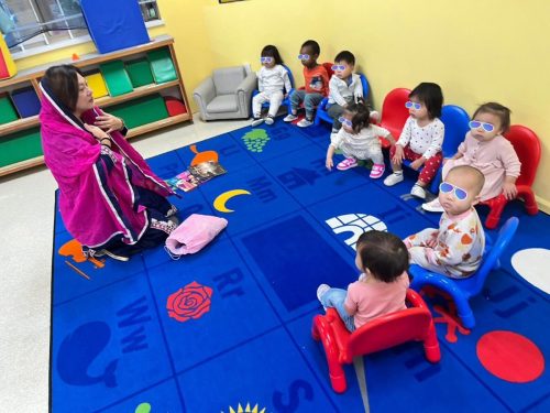 Infants at North Delta childcare listen to a Diwali story with their teacher.