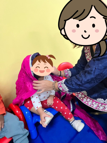 Infant at BKMCC Childcare in North Delta explores Diwali tradition with teacher’s help.