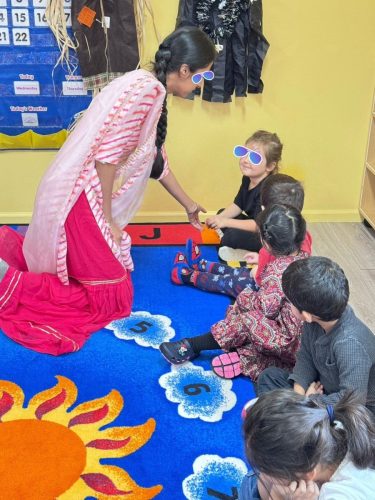 Teacher greeting children during Diwali activities at BKMCC North Delta