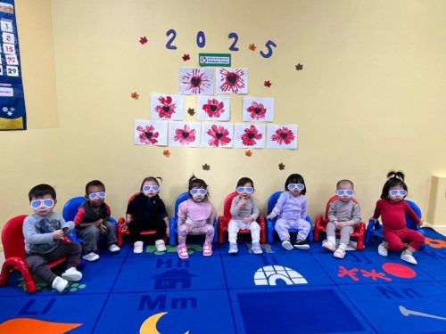 Infants at BKMCC Childcare in North Delta with handprint poppy art for Remembrance Day.